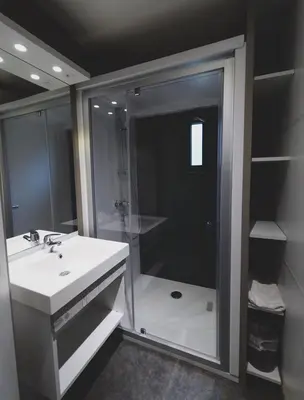 a bathroom with a shower and a white sink at Camping Les Oliviers in Porto Ota