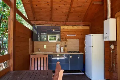 a kitchen with a stove and a refrigerator at Camping Les Oliviers in Porto Ota