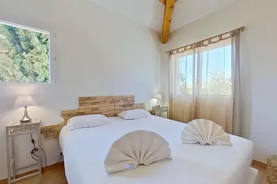 a bedroom with two beds and a window at Villas CALA CORSA - 3 chambres piscine partagée chauffée - CALA ROSSA Porto-Vecchio - Villas entièrement Climatisées - Internet gratuit in Porto-Vecchio