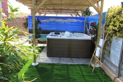 a hot tub under a pergola in a yard at Villas CALA CORSA - 3 chambres piscine partagée chauffée - CALA ROSSA Porto-Vecchio - Villas entièrement Climatisées - Internet gratuit in Porto-Vecchio