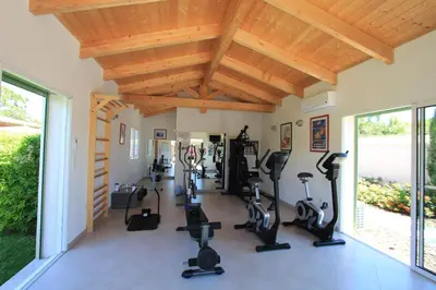 a gym with treadmills and exercise equipment in a room at Villas CALA CORSA - 3 chambres piscine partagée chauffée - CALA ROSSA Porto-Vecchio - Villas entièrement Climatisées - Internet gratuit in Porto-Vecchio
