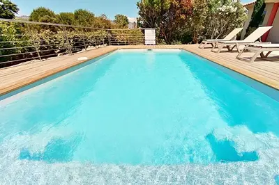 a swimming pool with blue water in a house at Villas CALA CORSA - 3 chambres piscine partagée chauffée - CALA ROSSA Porto-Vecchio - Villas entièrement Climatisées - Internet gratuit in Porto-Vecchio