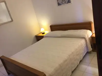 a small bedroom with a bed and two night stands at Résidence Playa Del'Oro in Favone