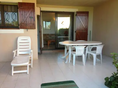 a patio with a table and chairs in a house at Résidence Playa Del'Oro in Favone
