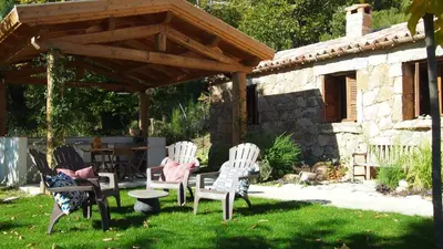 a group of chairs sitting under a wooden pergola at Bergerie avec piscine in Tasso