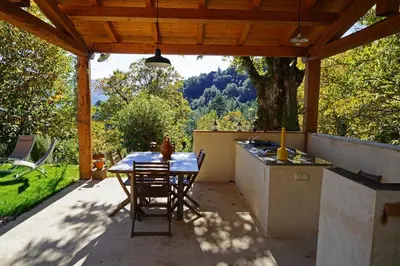 a patio with a table and a kitchen with a view at Bergerie avec piscine in Tasso