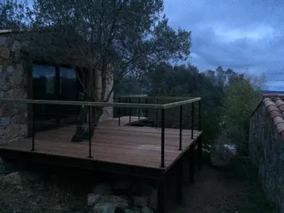 a house on a wooden deck with a tree at Les Jardins de Mathieu in Porto-Vecchio