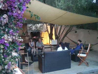 a group of people sitting in chairs under an umbrella at Les Jardins de Mathieu in Porto-Vecchio