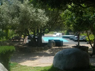 a swimming pool in a park with trees at Les Jardins de Mathieu in Porto-Vecchio