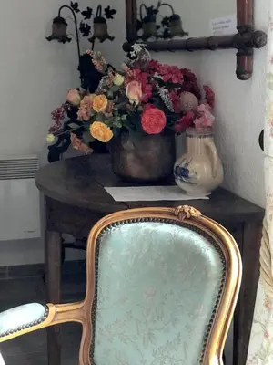 a chair and a vase of flowers on a table at U Fragnu di perruccio in Levie