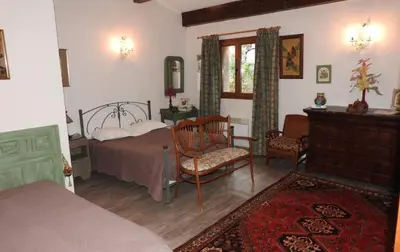 a bedroom with a bed and a chair and a table at U Fragnu di perruccio in Levie