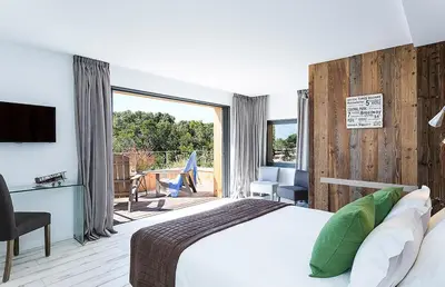 a bedroom with a large bed and a balcony at Les lofts de palombaggia in Porto-Vecchio