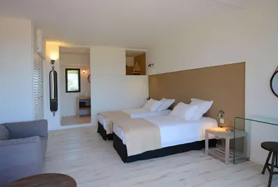 a hotel room with two beds and a couch at Les lofts de palombaggia in Porto-Vecchio