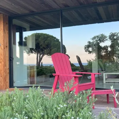 a red chair sitting in front of a window at Les lofts de palombaggia in Porto-Vecchio