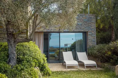 two white chairs sitting in front of a window at Les lofts de palombaggia in Porto-Vecchio