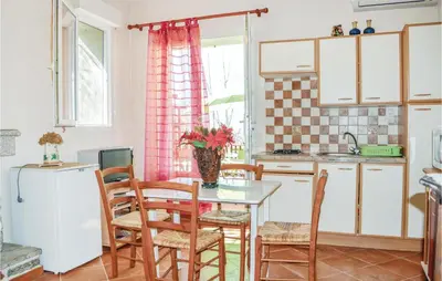 a kitchen with a table and chairs and a sink at 1 Bedroom Cozy Apartment In Zonza in Zonza
