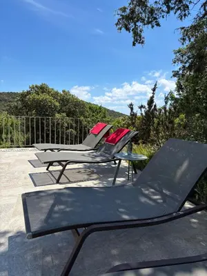 two lounge chairs and a table on a patio at Villa Giulia in Porto-Vecchio