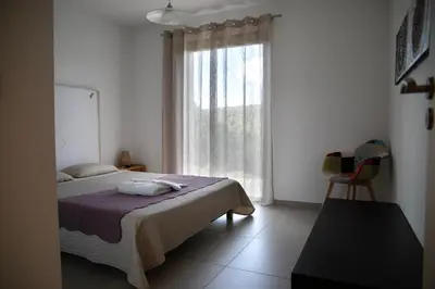 a bedroom with a bed and a large window at Villa Giulia in Porto-Vecchio
