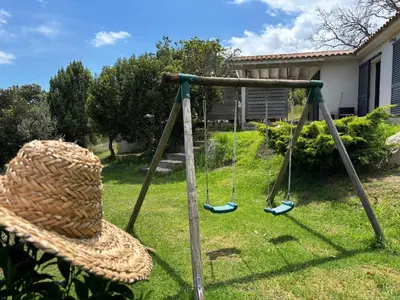 a swing in a yard with a hat on it at Villa Giulia in Porto-Vecchio