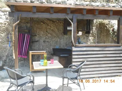 a table and chairs in front of a stone building at Les Bergeries 