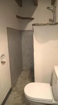 a bathroom with a white toilet and a sink at Les Bergeries 
