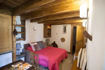 a bedroom with a bed with a red blanket at Les Bergeries 