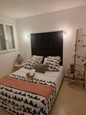 a bedroom with a large bed with black and white pillows at Les Chênes Verts in Corte