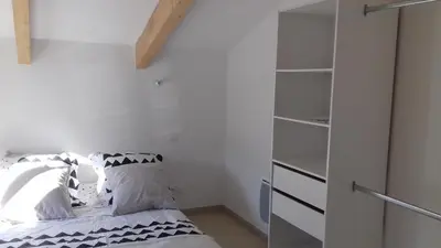a bedroom with white walls and a bed with pillows at Les Chênes Verts in Corte