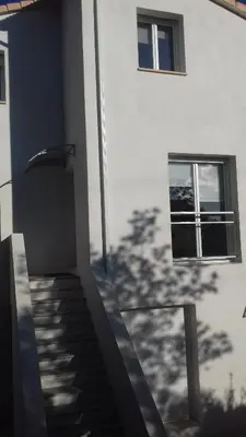 a shadow of a tree on the side of a building at Les Chênes Verts in Corte