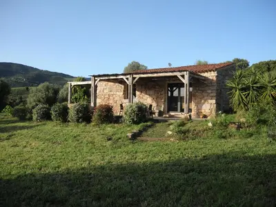 a stone house with a wooden pergola at Casa Lysandra in Serra-di-Ferro