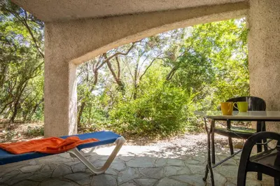 a patio with a table and a chair on a porch at La Tour in Linguizzetta
