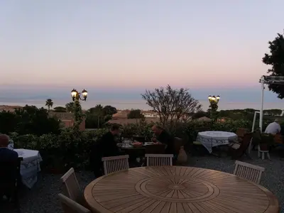 a group of people sitting around a table on a patio at La Tour in Linguizzetta