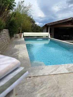 a swimming pool in a yard next to a house at Villa Santa in Porto-Vecchio