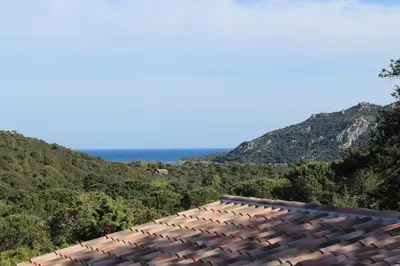 a roof of a house with mountains in the background at Villa Santa in Porto-Vecchio