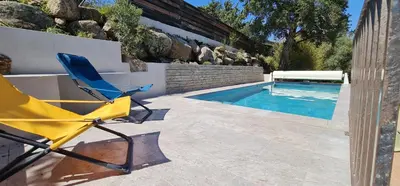 a yellow chair sitting next to a swimming pool at Villa Santa in Porto-Vecchio