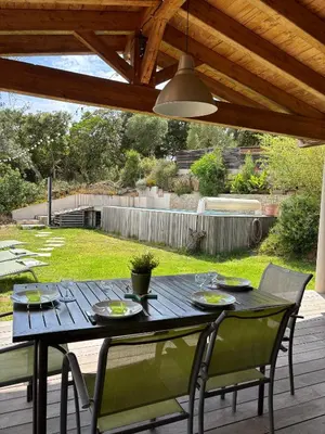 a black table and chairs on a patio with a ceiling at Villa Santa in Porto-Vecchio