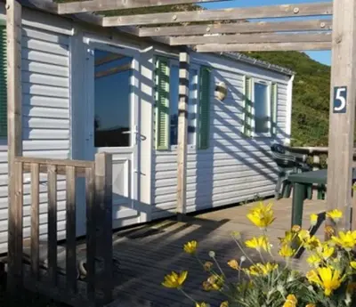 a tiny house with a porch and a table at La Canardiere in Casta