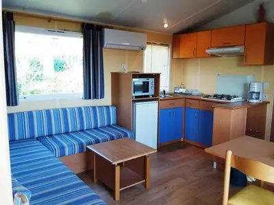 a living room with a couch and a kitchen at La Canardiere in Casta