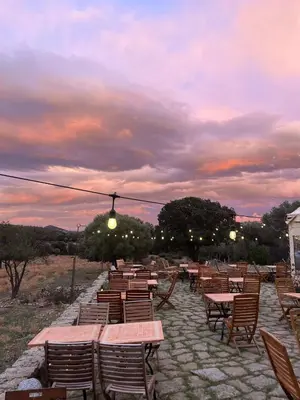 a row of tables and chairs with a sunset at L'Aghjalle in Santa-Reparata-di-Balagna