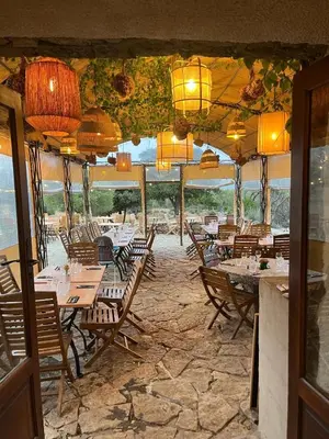 a dining room with tables and chairs and lights at L'Aghjalle in Santa-Reparata-di-Balagna