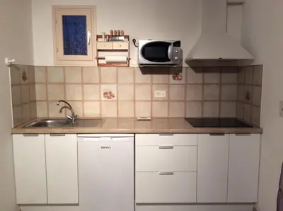 a small kitchen with a sink and a microwave at Rez de Villa Vue Mer Panoramique in Furiani