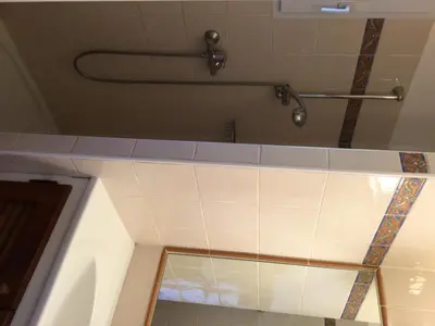 a shower in a bathroom with a tile wall at Villa Les Hameaux Di Santa Giulia in Porto-Vecchio