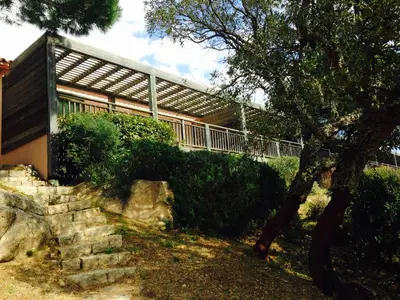a building with a tree and some rocks at Villa Les Hameaux Di Santa Giulia in Porto-Vecchio