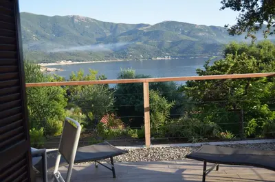 a balcony with a view of a lake and mountains at le relais de tiuccia in Casaglione