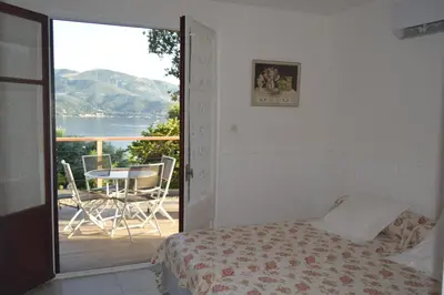 a bedroom with a bed and a balcony with a table at le relais de tiuccia in Casaglione