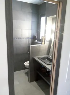 a bathroom with a sink and a toilet and a mirror at Appartement charmant à Olmeta di Tuda avec piscine partagée in Olmeta-di-Tuda