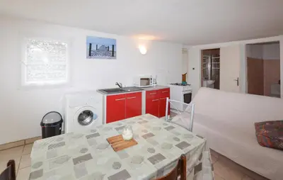 a room with a table and a kitchen with a washing machine at Villa Saint Nicolas in Coti-Chiavari