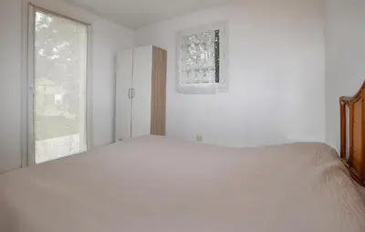 a white bedroom with a bed and a window at Villa Saint Nicolas in Coti-Chiavari
