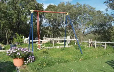 a swing set in a yard with flowers in the grass at Villa Saint Nicolas in Coti-Chiavari