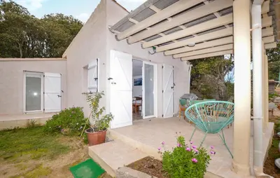 a patio with a green chair and a house at Villa Saint Nicolas in Coti-Chiavari